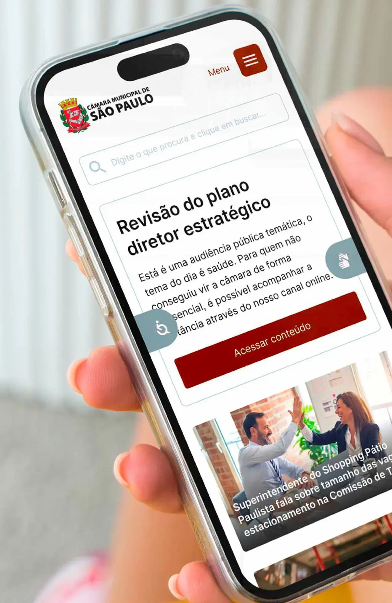 Portal da Câmara de São Paulo aberto no celular, com os botões de acessibilidade e de Libras visíveis nas laterais da tela, ao lado do conteúdo sobre uma audiência pública.